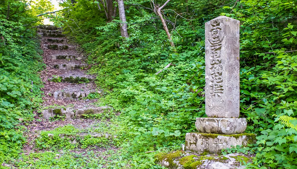 光明仏寺周辺や池の手前には石塔が建っています。